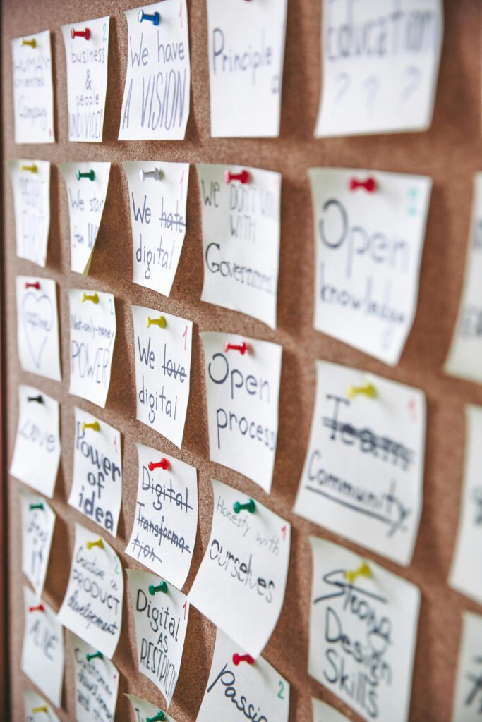 pexels-photo-3782229-3782229 Array of sticky notes pinned on corkboard with business ideas and goals.